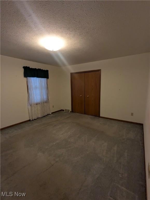 unfurnished bedroom with a closet, a textured ceiling, and carpet