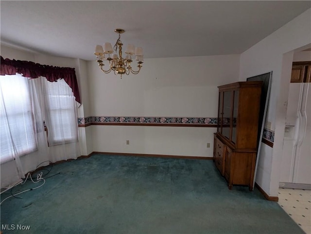 carpeted spare room with a chandelier