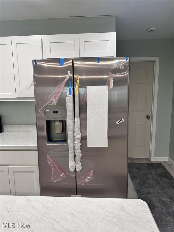 details with stainless steel fridge with ice dispenser and white cabinets