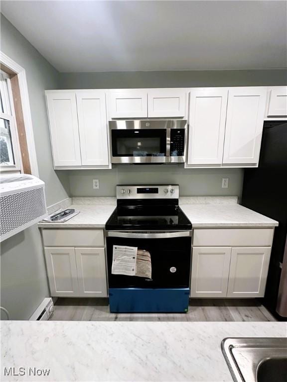 kitchen featuring white cabinetry, light hardwood / wood-style flooring, and appliances with stainless steel finishes