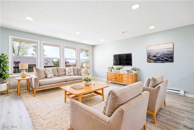 living room featuring a baseboard heating unit and light hardwood / wood-style floors