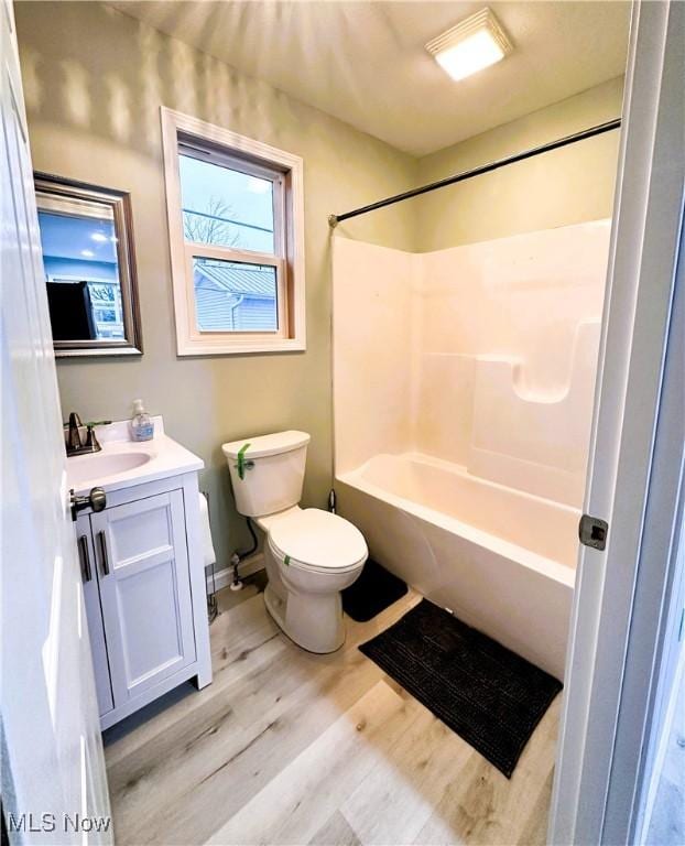 full bathroom featuring vanity, toilet, shower / bath combination, and hardwood / wood-style floors