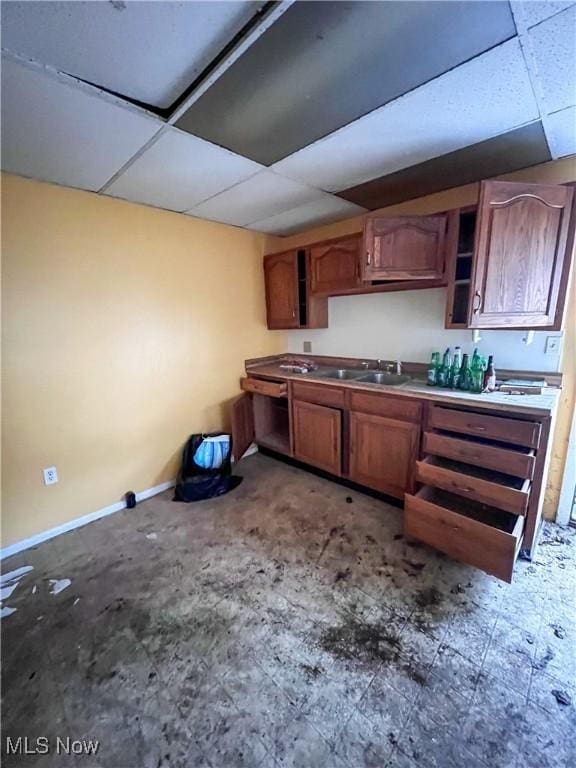 kitchen featuring a drop ceiling and sink