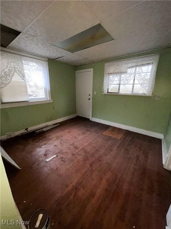 unfurnished room with wood-type flooring and a paneled ceiling