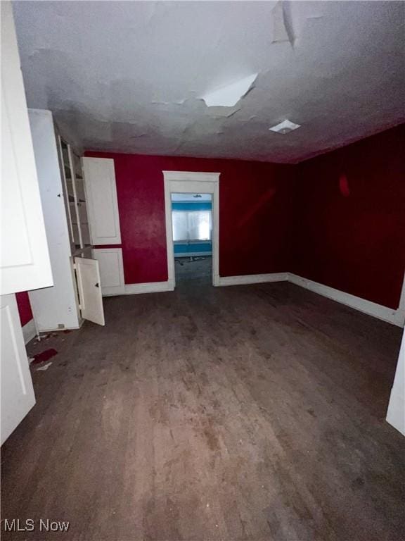 spare room with dark wood-type flooring and a textured ceiling