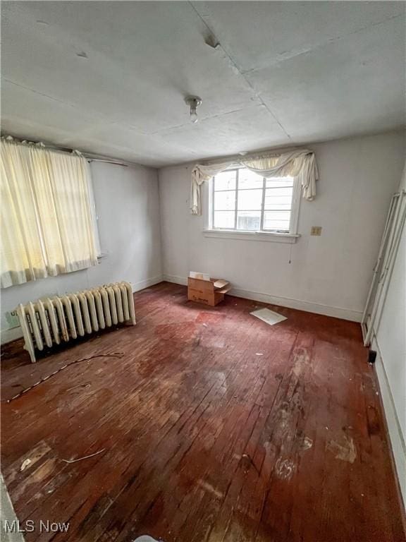 unfurnished room featuring hardwood / wood-style flooring and radiator