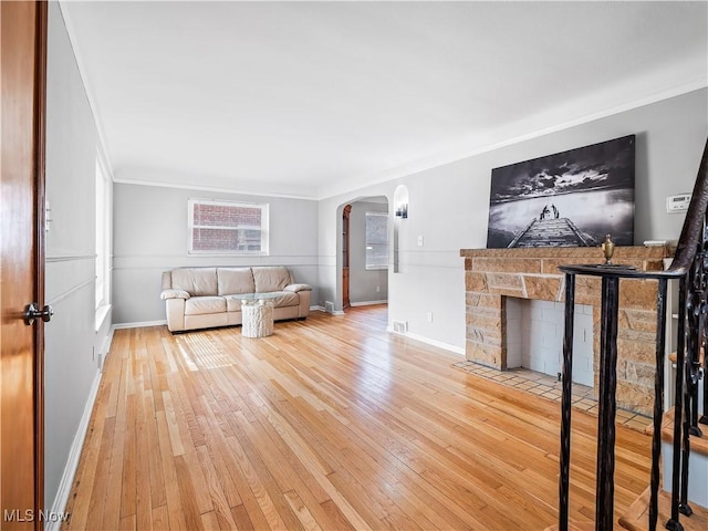 unfurnished living room featuring ornamental molding, wood-type flooring, and a fireplace