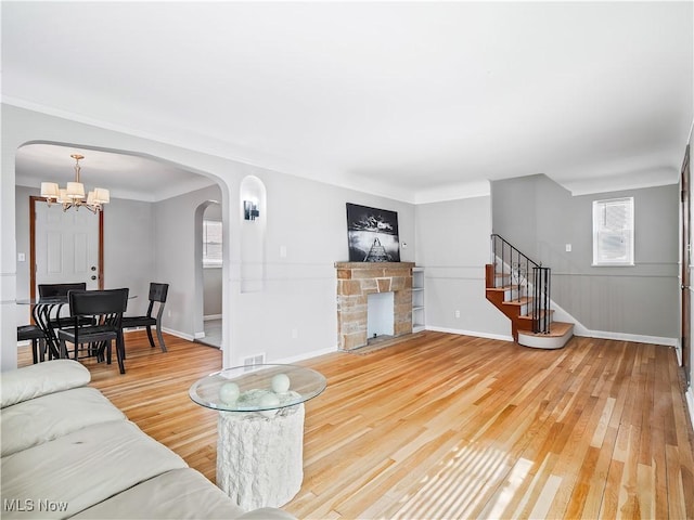 living room with hardwood / wood-style flooring, a fireplace, and an inviting chandelier