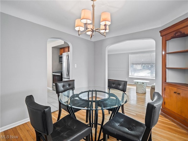 dining area featuring an inviting chandelier and light hardwood / wood-style flooring