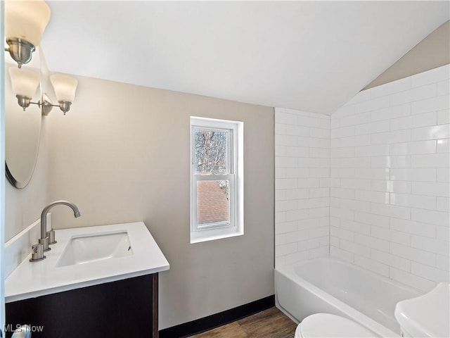 full bathroom featuring toilet, tub / shower combination, vaulted ceiling, vanity, and hardwood / wood-style flooring