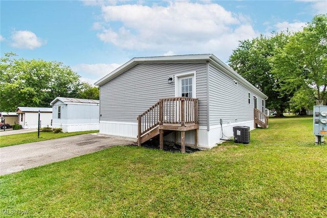 view of front of home with a front yard and central air condition unit