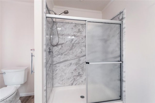 bathroom with an enclosed shower, wood-type flooring, ornamental molding, and toilet