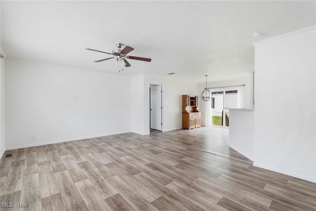 unfurnished living room with ceiling fan with notable chandelier and light hardwood / wood-style flooring