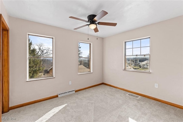 spare room with ceiling fan and light carpet