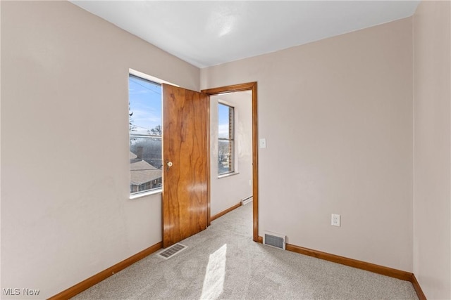 carpeted empty room featuring a baseboard radiator