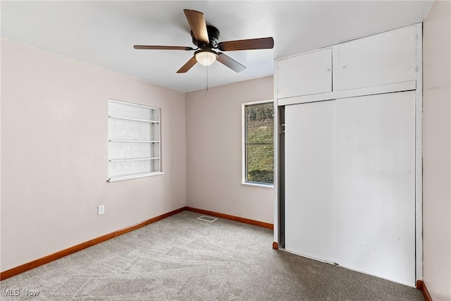 unfurnished bedroom featuring carpet floors, ceiling fan, and a closet