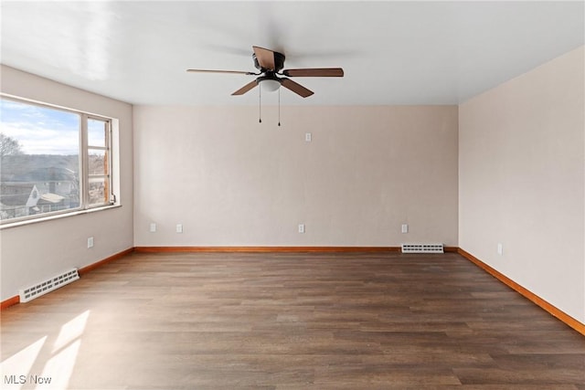 empty room with dark hardwood / wood-style flooring and ceiling fan