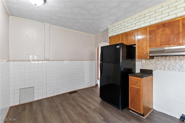 kitchen with ornamental molding, black refrigerator, a textured ceiling, and dark hardwood / wood-style floors