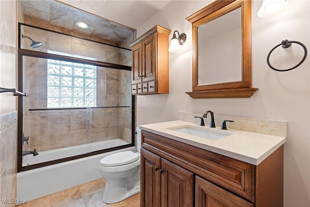 full bathroom featuring toilet, tile patterned floors, vanity, and shower / bath combination with glass door