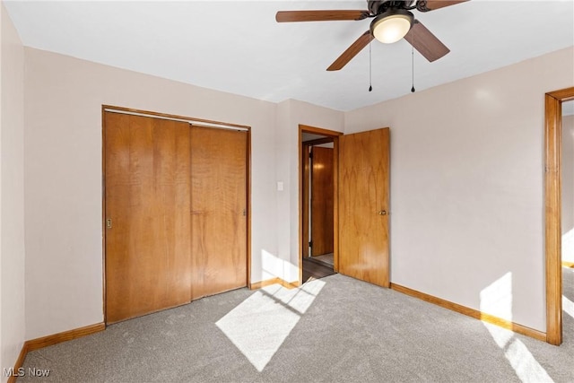 unfurnished bedroom with light colored carpet, ceiling fan, and a closet