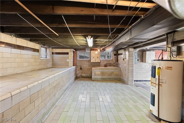 basement with a healthy amount of sunlight and water heater