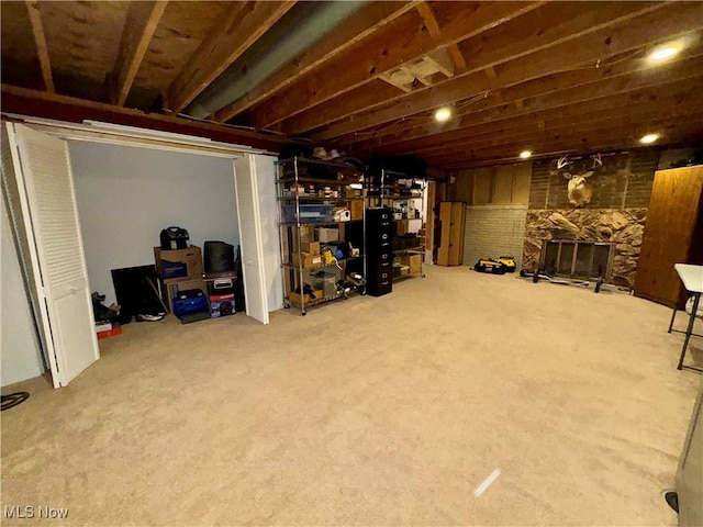 basement with a fireplace and carpet