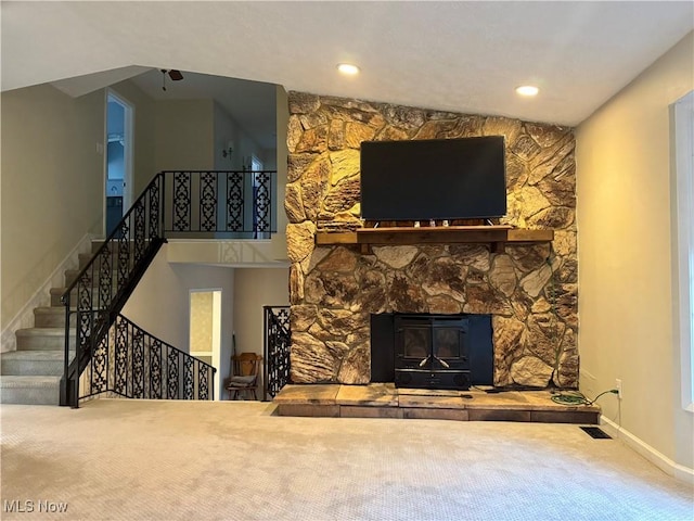 carpeted living room with a wood stove