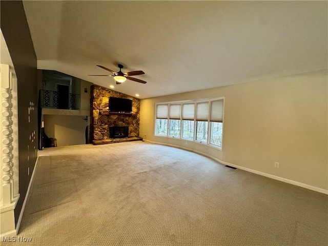 unfurnished living room featuring lofted ceiling, carpet floors, a fireplace, and ceiling fan