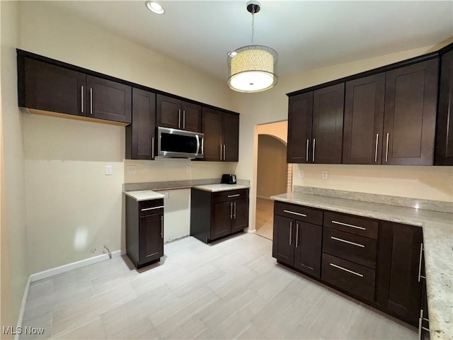 kitchen featuring pendant lighting and dark brown cabinets