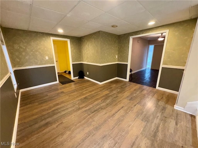 empty room featuring a drop ceiling and wood-type flooring