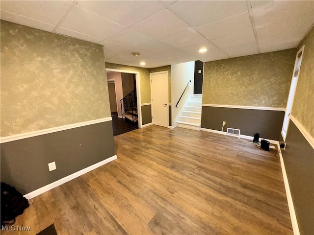 basement with hardwood / wood-style floors and a drop ceiling