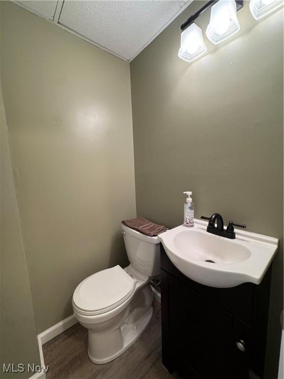 bathroom with wood-type flooring, toilet, and vanity