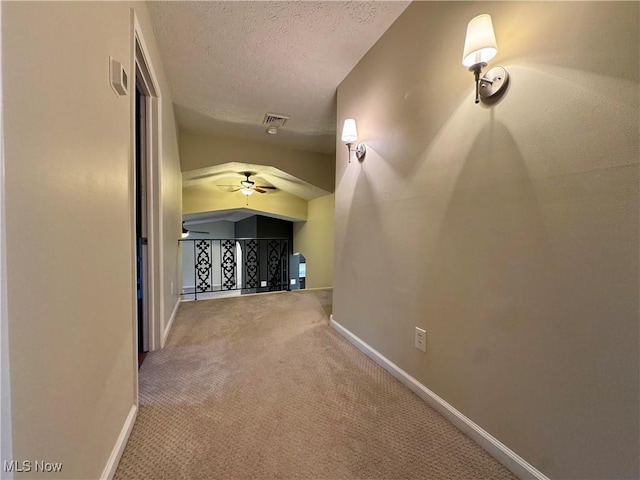 corridor featuring carpet floors and a textured ceiling