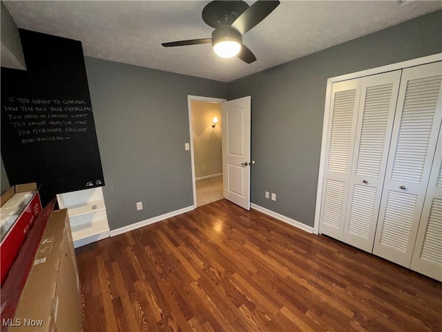 unfurnished bedroom featuring a closet, dark hardwood / wood-style floors, and ceiling fan