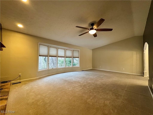 interior space featuring lofted ceiling, carpet flooring, a textured ceiling, and ceiling fan