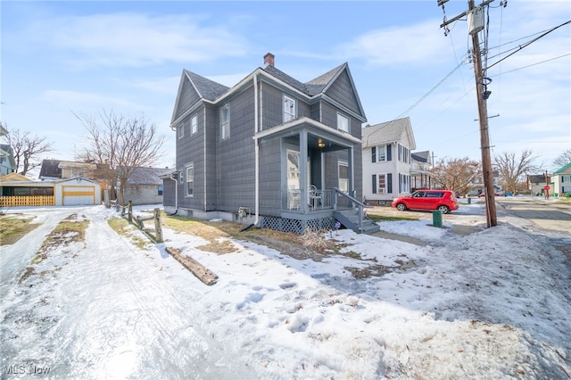 view of snowy exterior with a garage and an outdoor structure