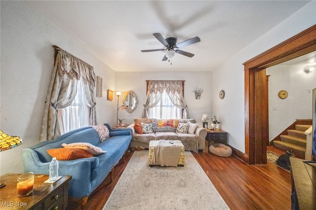 living room featuring dark wood-type flooring and ceiling fan