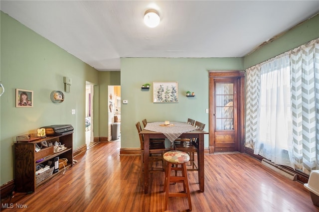 dining area featuring hardwood / wood-style flooring and a baseboard heating unit