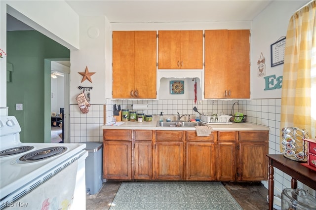 kitchen featuring tile walls, sink, and white range with electric stovetop