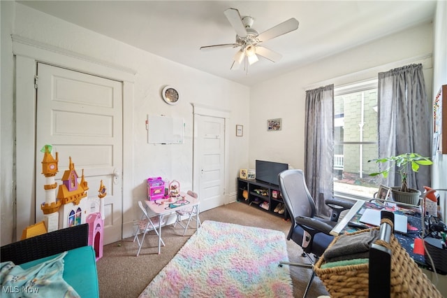 carpeted office space with ceiling fan