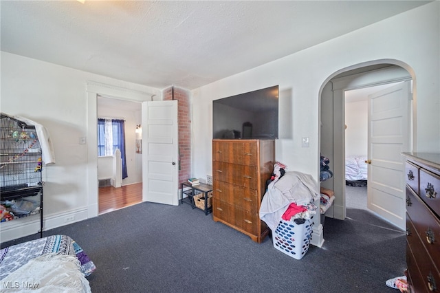 bedroom with dark carpet and a textured ceiling