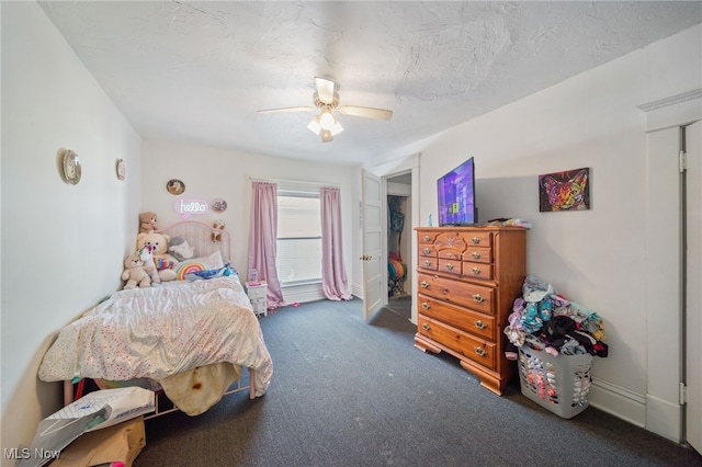 carpeted bedroom with ceiling fan and a textured ceiling