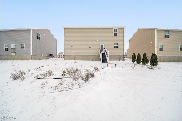 view of snow covered back of property