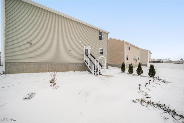 view of snow covered back of property