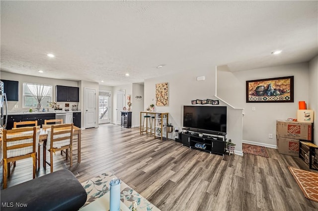 living room with sink, hardwood / wood-style floors, and a textured ceiling