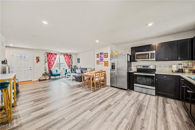 kitchen with light hardwood / wood-style floors and appliances with stainless steel finishes