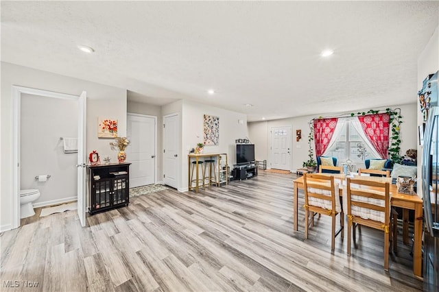 dining area featuring a textured ceiling and light wood-type flooring