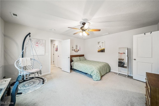 carpeted bedroom with a textured ceiling and ceiling fan