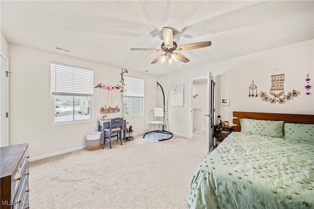 bedroom with ceiling fan, carpet flooring, and a textured ceiling