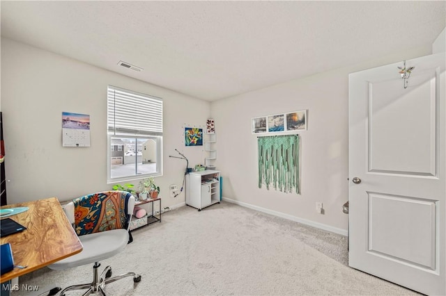 carpeted home office featuring a textured ceiling